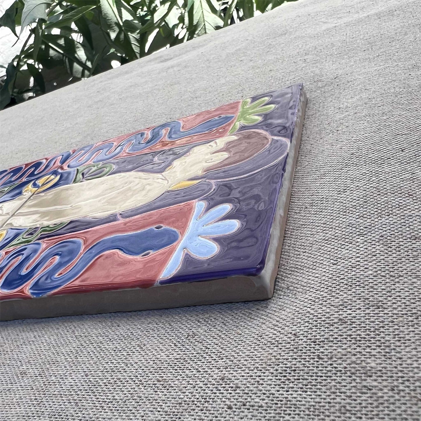 Close-Up of Male Nude Painted on Tile Place on Grey Fabric in a Garden