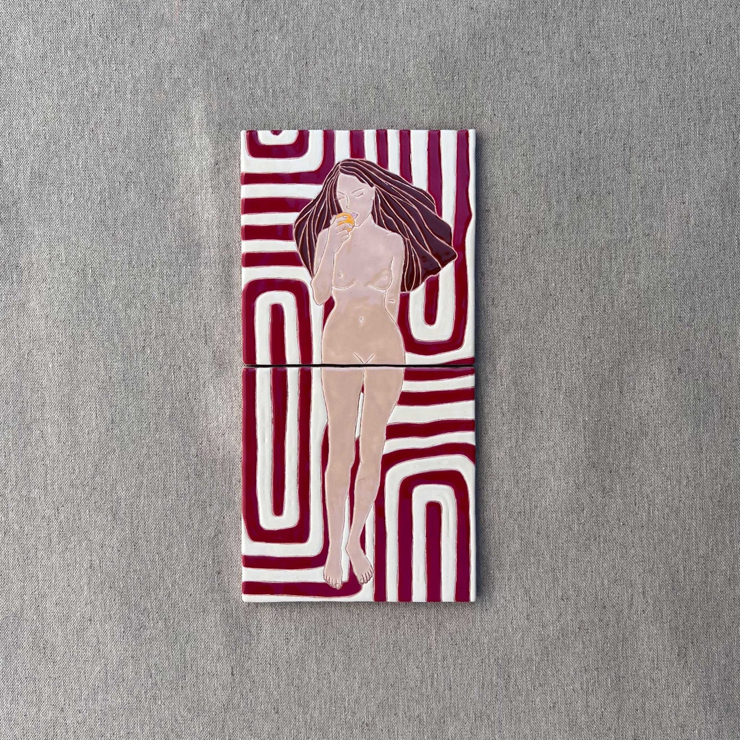 A Hand-Painted Tile Mural of a Female Nude on a Patterned Background