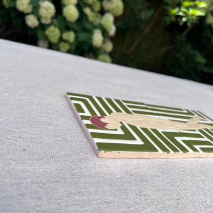Close-up of a tile diptych on grey background showing a pensive male nude against a patterned green and white background